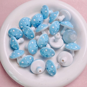 Close-up of sky blue polka dot mushroom acrylic beads for DIY jewelry and crafts
