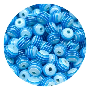 Vista macro di perline acriliche a strisce blu e bianche con fori per gioielli fai-da-te