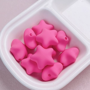 Macro detail of rose pink star-shaped acrylic beads with matte finish for DIY jewelry crafts
