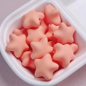 Macro detail of macaron star acrylic beads with a smooth matte cream finish for DIY crafts