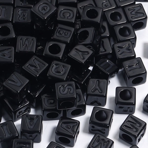 Vue macro de perles lettres carrées noires en acrylique pour bijoux DIY et bracelets