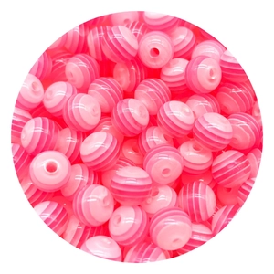 Dettaglio di perle rotonde a righe rosa con fori centrali per gioielli fai-da-te