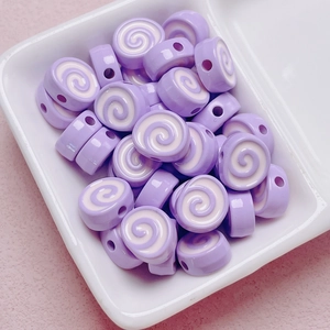 Macro shot of purple swirl acrylic Swiss roll beads for DIY jewelry and phone charms