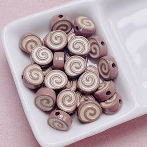 Detailed macro view of acrylic swiss roll swirl beads for DIY craft and keychain projects