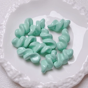 Close-up of mint green spiral acrylic beads for DIY handmade jewelry and craft accessories