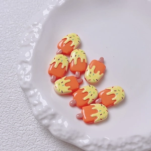 Detailweergave van negen oranje acryl ijsjesbedeltjes met kleurrijke hagelslag voor DIY knutselen