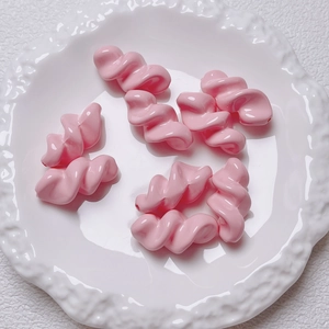 Close-up of pink spiral acrylic fusilli-shaped beads for DIY handmade jewelry crafts