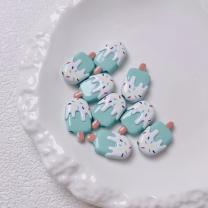 Detailopname van tien blauw-witte ijslolly kralen op een wit keramisch bloemenbordje