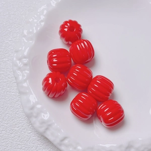 Macro view of glossy red pumpkin-shaped acrylic beads for DIY jewelry and phone chains