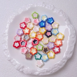 Colorful mixed acrylic flower beads for DIY crafts displayed on a white textured plate
