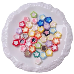 Colorful acrylic flower beads in a white ceramic tray for DIY jewelry making