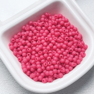 Detail of 4mm rose pink rubber finish beads for DIY jewelry making in a white container