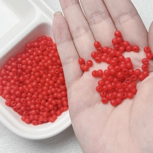 Macro shot of 4mm red matte beads showing soft rubber texture for DIY jewelry making