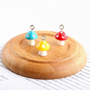 Colorful resin mushroom pendants with white dots and metal loops for DIY jewelry