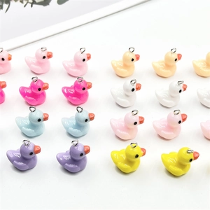 Macro shot of colorful mini resin duck pendants with silver metal loops for DIY jewelry