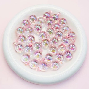 Macro shot of 16mm pink iridescent acrylic beads for DIY jewelry making in a white bowl