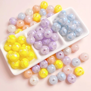 Macro detail of 16mm colorful candy acrylic beads with heart patterns and glitter