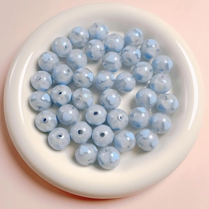 Macro detail of 16mm glitter acrylic round beads with blue heart pattern for DIY crafts