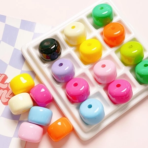 Macro shot of colorful acrylic macaron beads organized in a white display tray for DIY crafts