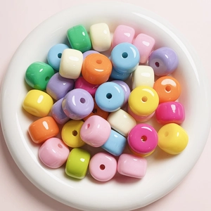 Macro shot of colorful acrylic beads in a white bowl for DIY jewelry and phone charms
