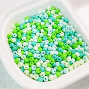 Close-up of 4mm mixed pastel glass seed beads in a white container for DIY jewelry making