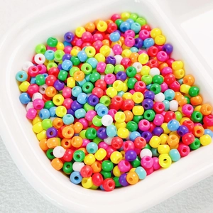 Macro shot of 4mm high-quality colorful Czech glass seed beads in a white tray for DIY crafts