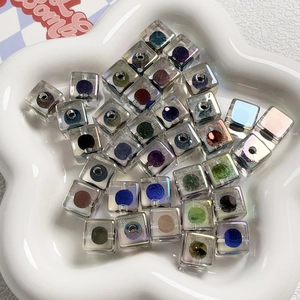 Vista macro di perle a cubo iridescenti con nuclei colorati e rivestimento AB nel vassoio