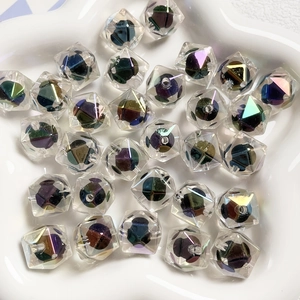 Dettaglio macro di perle nere sfaccettate con finitura UV e riflessi iridescenti