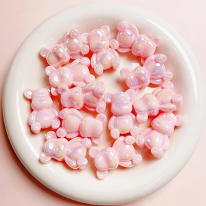 Dettaglio macro di perline a forma di orso rosa cangiante con rivestimento UV 3D per DIY
