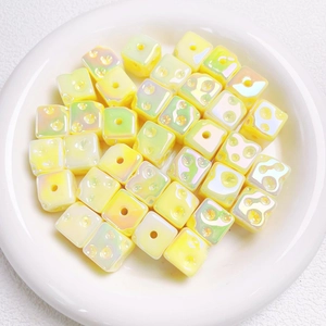 Macro shot of pale yellow pearlescent square cube beads for DIY jewelry making