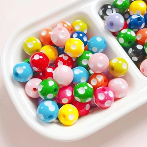 Close-up of colorful polka dot resin 12mm round beads for DIY jewelry making and crafts