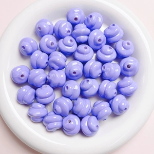 Close-up of glossy purple spiral beads for DIY jewelry and phone chain crafting
