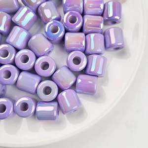 Macro shot of iridescent purple acrylic barrel beads with a pearlescent finish for DIY jewelry