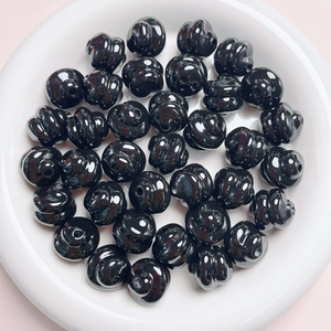 Macro shot of black glossy spiral pumpkin beads for DIY jewelry and phone chain making