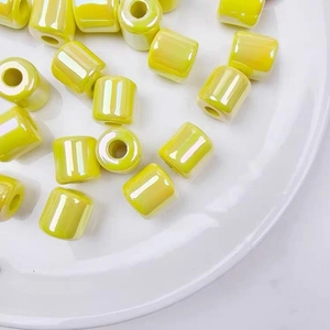 Macro shot of glossy bright yellow UV-plated acrylic barrel beads for DIY jewelry crafts