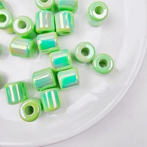 Macro detail of glossy light green iridescent acrylic barrel beads for DIY jewelry making