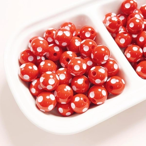 Close-up of 12mm red resin beads with white polka dots for DIY jewelry making
