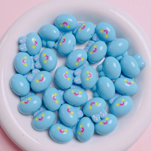 Detail of light blue acrylic cartoon bunny beads for DIY jewelry making on a plate