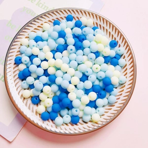 Macro detail of 6mm colorful matte acrylic beads for DIY crafts in a ceramic dish