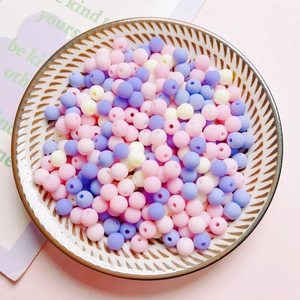 Close-up of matte 6mm colorful acrylic round beads in a dish for DIY craft jewelry