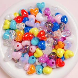 Colorful heart-shaped acrylic beads set for DIY jewelry making in a white ceramic bowl