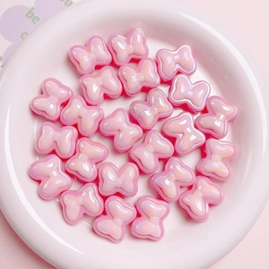 Detailed view of pink macaron bow beads with pearlescent finish for DIY jewelry making
