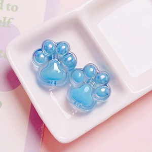Detail of blue translucent acrylic cat paw charms with vertical holes for DIY jewelry