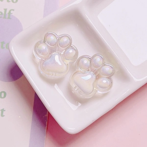 Macro view of pearlescent white cat paw beads for DIY jewelry and phone charms