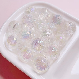Macro shot of iridescent crackle glass beads for DIY jewelry in a white square tray