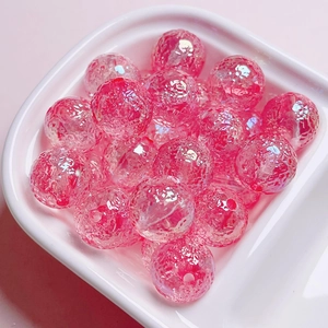 Pink ice-crackled texture glass beads for jewelry making in a white ceramic dish