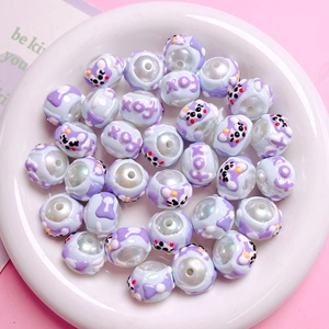 Macro detail of hand-painted pearlescent acrylic beads with cartoon animals and bows
