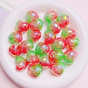 Primer plano de cuentas de corazón de vidrio craquelado con degradado rojo y verde en plato