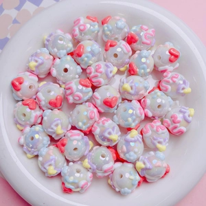 Macro shot of iridescent white acrylic beads with colorful 3D heart-shaped relief patterns