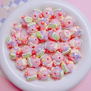 Macro shot of colorful DIY acrylic beads with hand-painted Lucky text on a white plate
